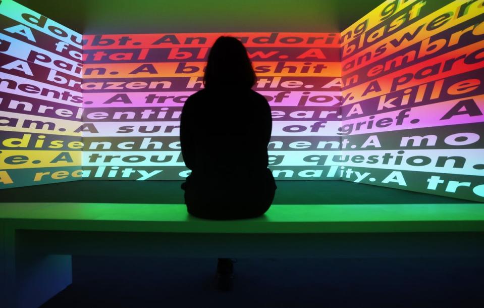 A Serpentine Gallery worker looks at a video work by US artist Barbara Kruger (EPA)