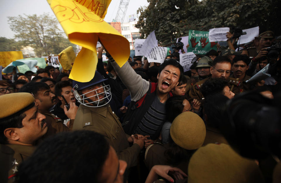 Indian police stop a student from the northeastern state of India as he shouts slogans during a protest in New Delhi, India, Saturday, Feb. 1, 2014. The beating and subsequent death in New Delhi of a university student, 20-year-old Nido Tania, from India's remote northeast has sparked a furious outcry against racism and criticism of police in the Indian capital. (AP Photo/Altaf Qadri)