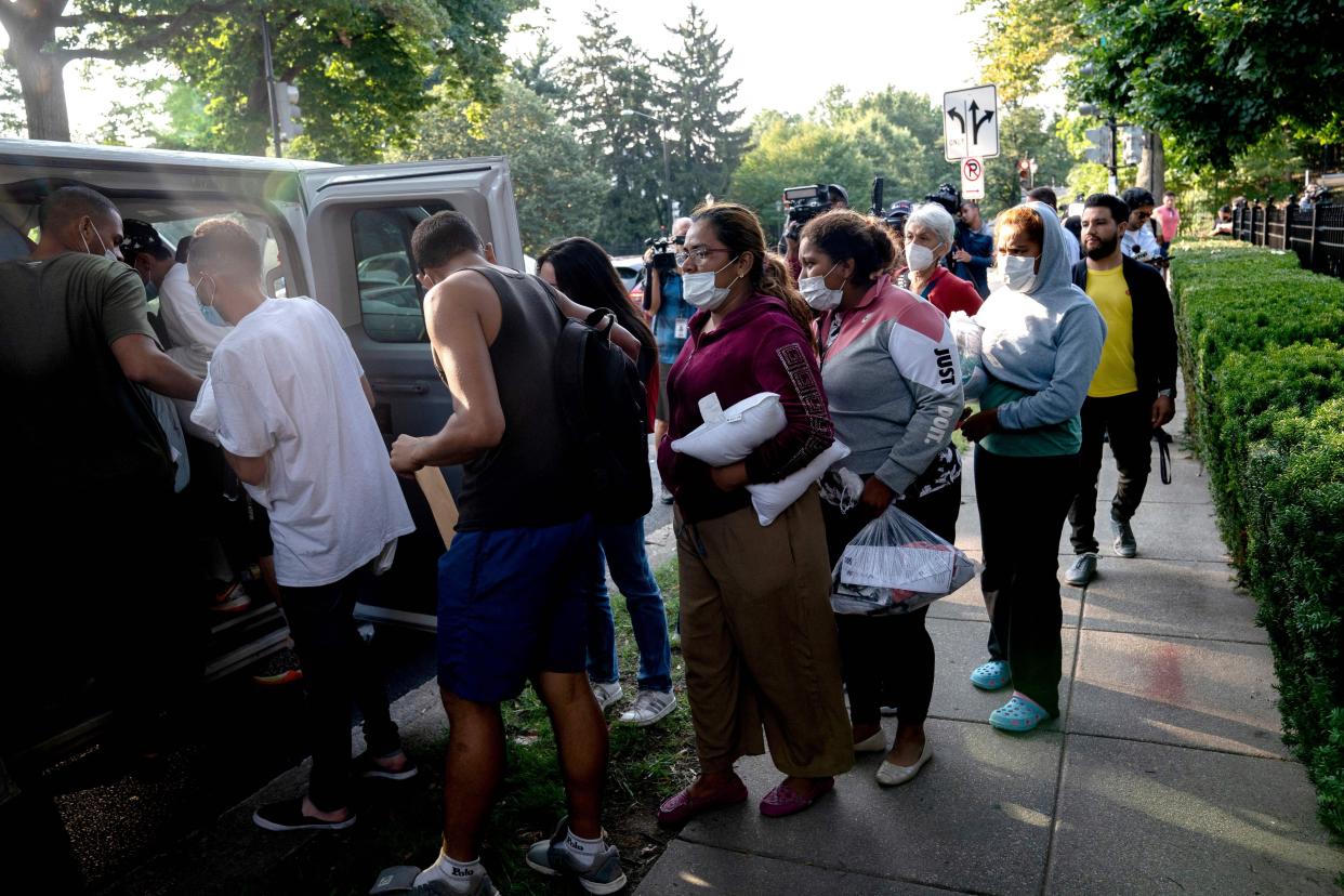 Migrants from Venezuela, who boarded a bus in Texas, wait to be transported to a local church by volunteers after being dropped off outside the residence of Vice President Kamala Harris in Washington, D.C., on Sep. 15, 2022. 