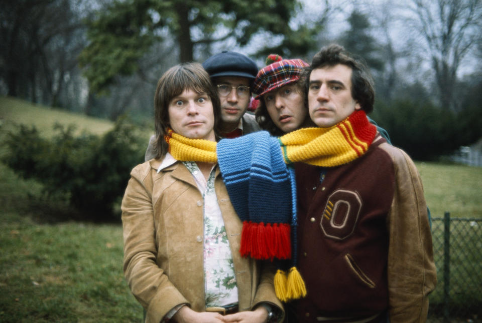 Comedians from the British comedy troupe Monty Python pose with a large scarf around their necks during a visit to Paris. (L-R): Terry Gilliam, musician and supporting player Neil Innes, Eric Idle, and Terry Jones. (Photo by Pierre Vauthey/Sygma/Sygma via Getty Images)