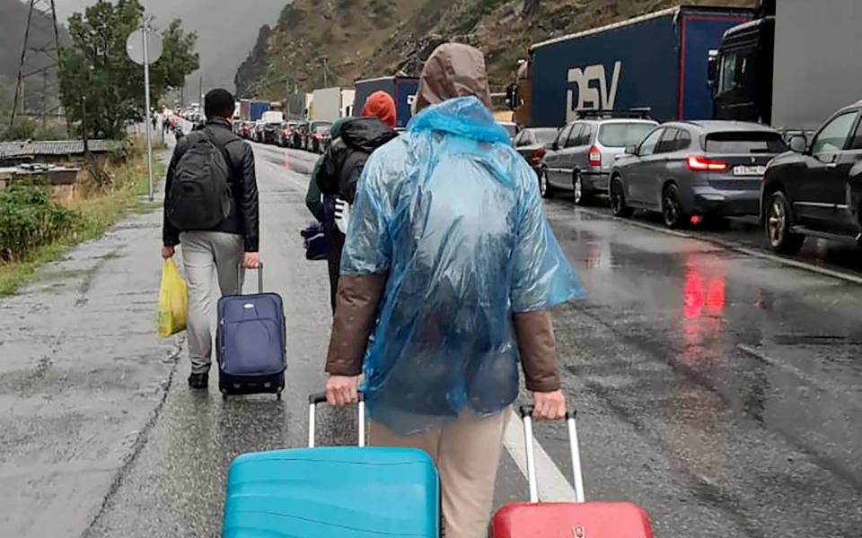 Russians queue to cross into Georgia. - AFP