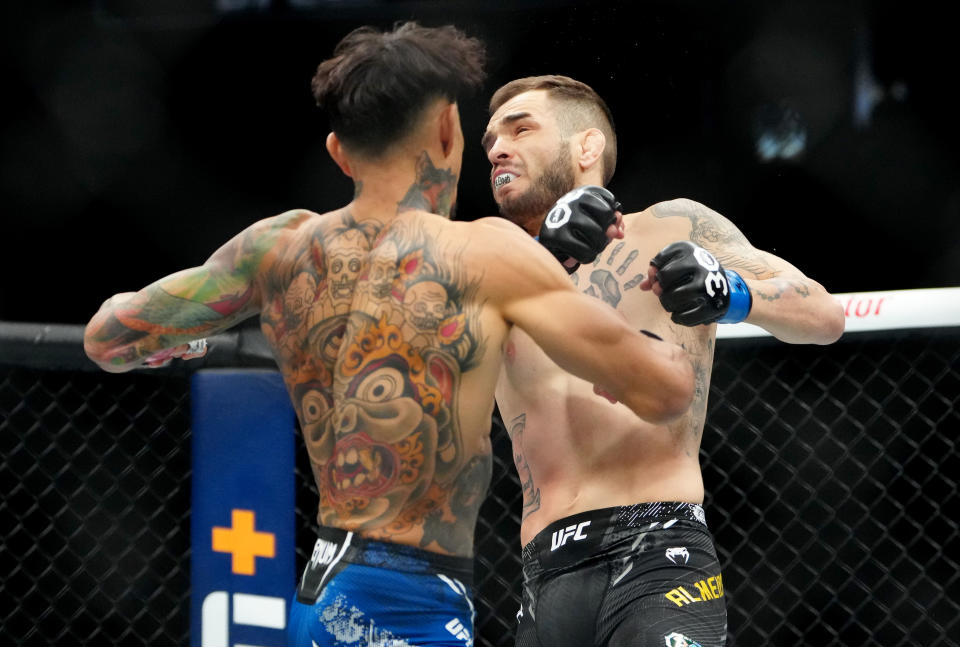Dec 16, 2023; Las Vegas, Nevada, USA; Andre Fili (red gloves) fights Lucas Almeida (blue gloves) during UFC 296 at T-Mobile Arena. Mandatory Credit: Stephen R. Sylvanie-USA TODAY Sports