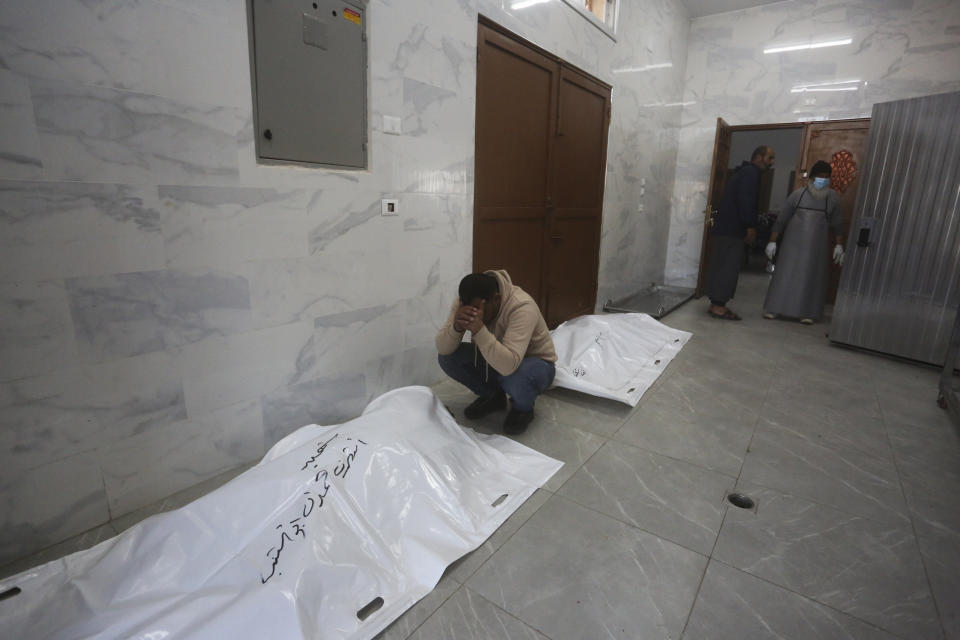 A Palestinian mourns relatives killed in the Israeli bombardment of the Gaza Strip in Khan Younis, Tuesday, Dec. 26, 2023. (AP Photo/Hatem Ali)