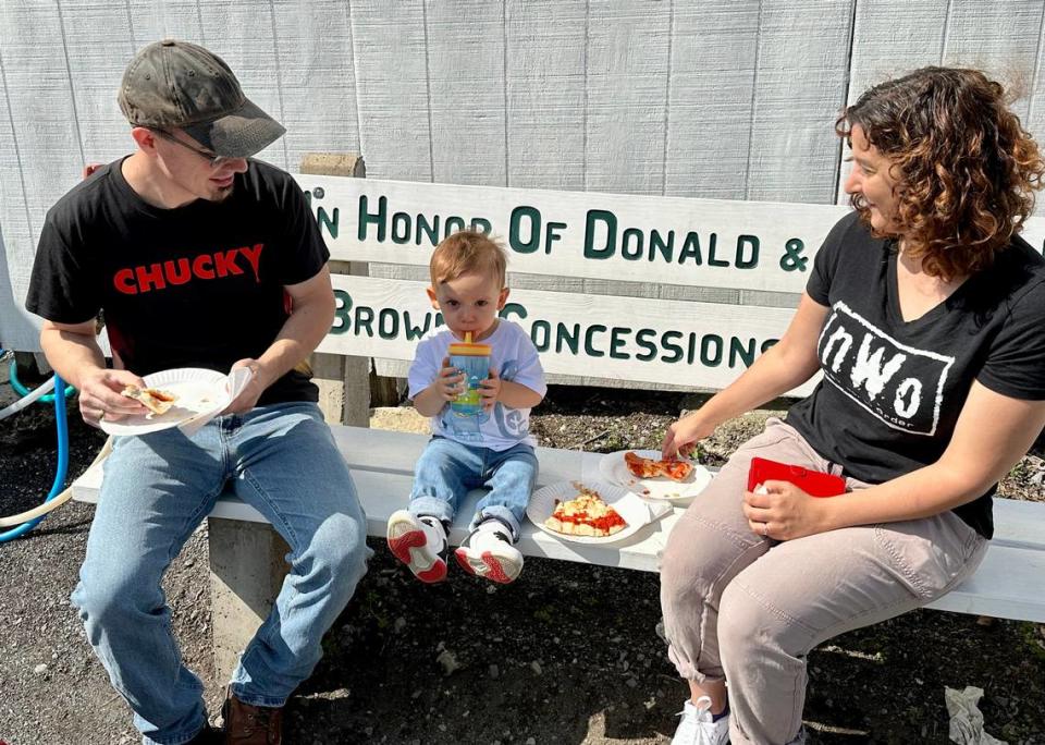 Mike Harrison of Huntingdon, Kristin Ieraci of Huntington, and 18-month-old Gabriel enjoy some pizza at Grange Fair on Saturday, Aug. 19, 2023.