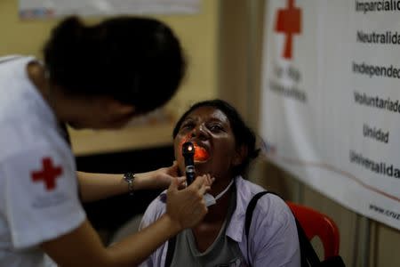 Eufemia Garcia, 48, who lost 50 members of her family during the eruption of the Fuego volcano, is examined by a doctor after a long day searching for her family in Escuintla, Guatemala, June 14, 2018. REUTERS/Carlos Jasso