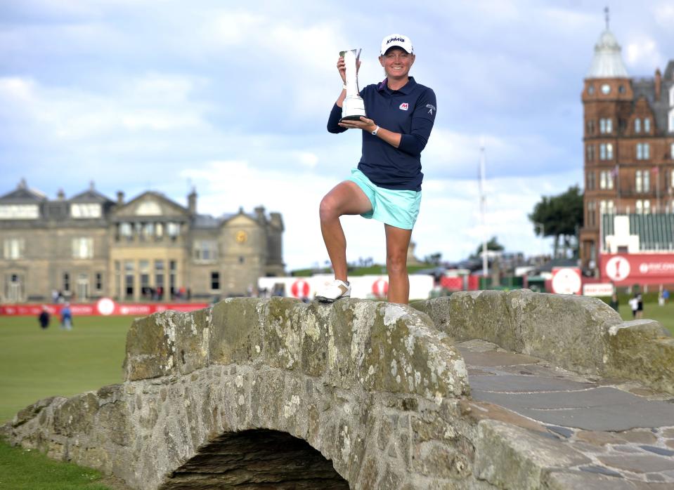 US golfer Stacy Lewis poses with the trophy on the Swilcan Bridge after winning the women's British Open Golf Championship at the Old Course in St Andrews, Scotland, on August 4, 2013. US golfer Stacy Lewis won the women's British Open on Sunday by two shots. Lewis, the winner of the 2011 Kraft Nabisco Championship, collected her second major with a final round 72 for an eight-under-par total of 280. AFP PHOTO/ANDY BUCHANAN    (Photo credit should read Andy Buchanan/AFP via Getty Images)