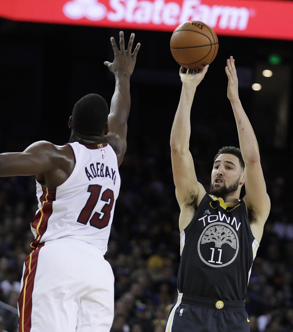 Golden State Warriors' Klay Thompson, right, shoots against Miami Heat center Bam Adebayo (13) during the second half of an NBA basketball game, Sunday, Feb. 10, 2019, in Oakland, Calif. (AP Photo/Ben Margot)