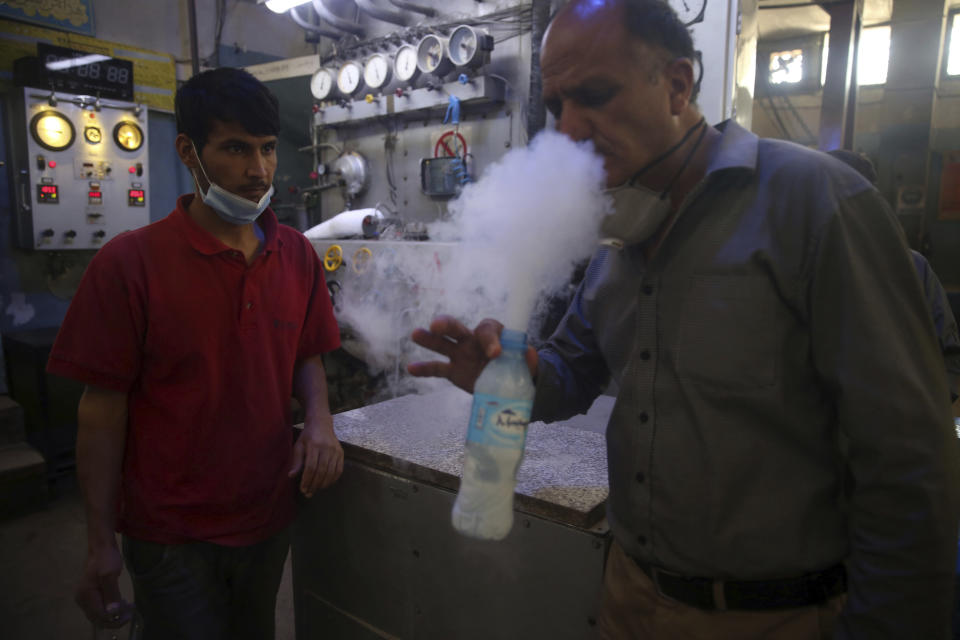 A man tests oxygen at a privately owned oxygen factory, in Kabul, Afghanistan, Thursday June 18, 2020. For seven years, Najibullah Seddiqi's oxygen factory sat idle in the Afghan capital Kabul. He shut it down, he says, because corruption and power cuts made it impossible to work. But when the novel coronavirus began racing through his country, he opened the factory's dusty gates and went back to work. Now he refills hundreds of oxygen cylinders a day for free for COVID-19 patients — and at reduced rates for hospitals. (AP Photo/Rahmat Gul)