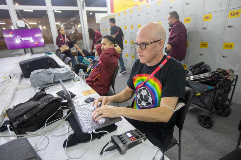 AL RAYYAN, QATAR - NOVEMBER 21: Journalist Grant Wahl (right) works in the FIFA Media Center before a FIFA World Cup Qatar 2022 Group B match between Wales and USMNT at Ahmad Bin Ali Stadium on November 21, 2022 in Al Rayyan, Qatar. He had been detained earlier by stadium security for wearing a rainbow-colored t-shirt before later being allowed to enter the stadium. (Photo by Doug Zimmerman/ISI Photos/Getty Images)