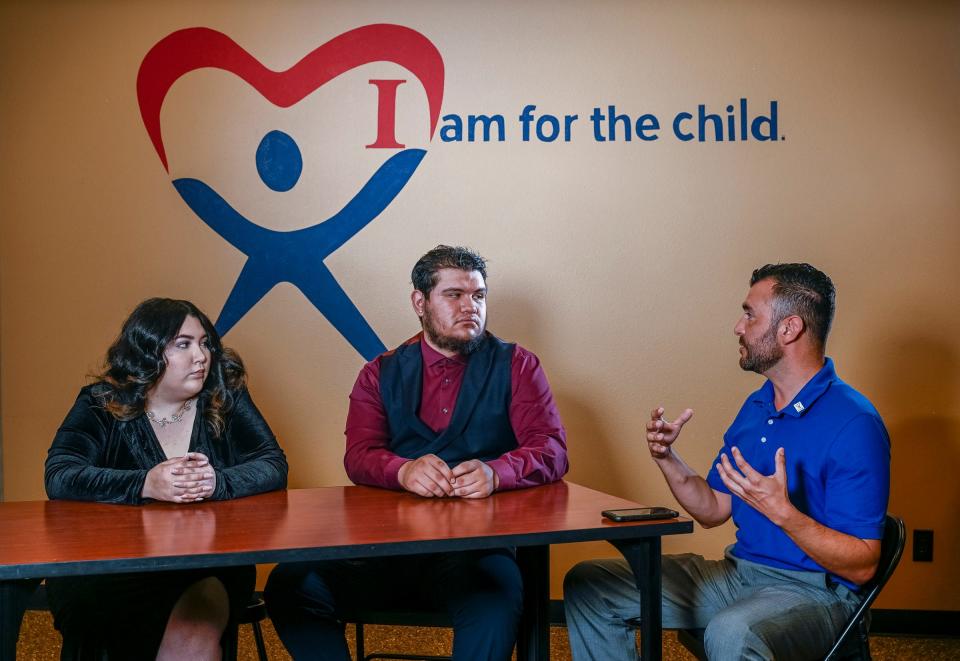 Former foster children Cheyenne Droney, left, and Saul Zavala talk with Executive Director Alberto Ramos about their role in CASA's upcoming annual gala in May.