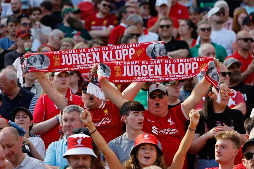 Liverpool fans hold up Jürgen Klopp the head coach / manager of Liverpool scarves during the Premier League match between Liverpool FC and Wolverhampton Wanderers at Anfield on May 19, 2024 in Liverpool, England.