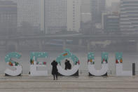 A woman wearing a face mask to help protect against the spread of the coronavirus poses for pictures at a park in Seoul, South Korea, Tuesday, Jan. 26, 2021. (AP Photo/Ahn Young-joon)