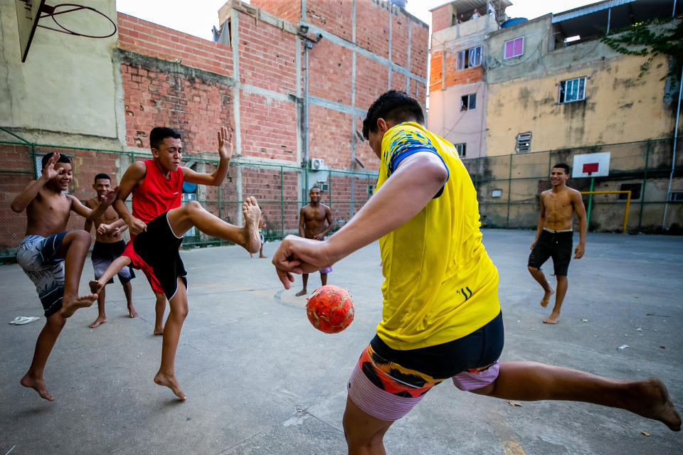 RIO DE JANEIRO, BRAZIL - MARCH 28: A group of boys play soccer outside at Piscinao de Ramos community amidst the coronavirus (COVID-19) pandemic on March 28, 2020 in Rio de Janeiro, Brazil. According to the Ministry of health, as of today, Brazil has 3.417 confirmed cases of the coronavirus (COVID-19) and at least 92 recorded deceases. (Photo by Buda Mendes/Getty Images)