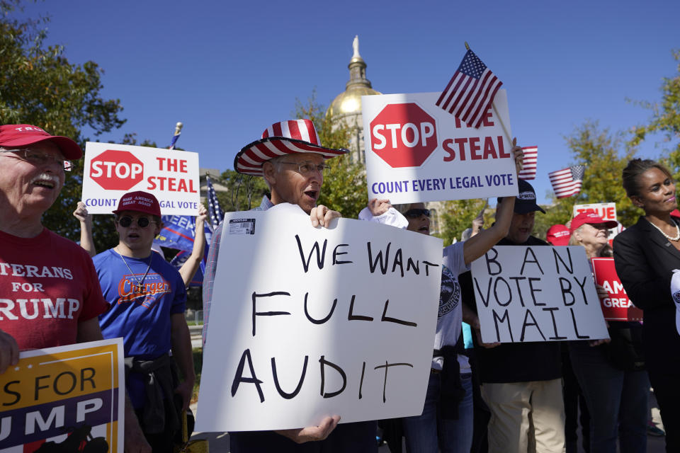 FILE - Supporters of President Donald Trump hold signs during a rally outside the Georgia State Capitol, Nov. 13, 2020, in Atlanta. (AP Photo/John Bazemore, File)