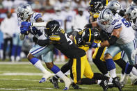 Dallas Cowboys running back Rico Dowdle (34) tries to escape the grasp of Pittsburgh Steelers linebacker Ulysees Gilbert III during the first half of the Pro Football Hall of Fame NFL preseason game Thursday, Aug. 5, 2021, in Canton, Ohio. (AP Photo/Ron Schwane)