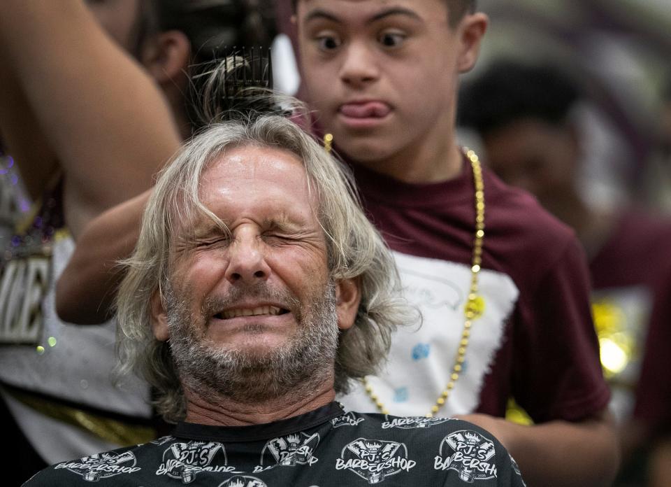 Riverdale athletic director Justin Budmayr reacts to having his head shaved during a pep rally on Friday, Sept. 23, 2022, at Riverdale High School. The event was to raise money for Golisano Children's Hospital and to raise awareness during Childhood Cancer Awareness Month.