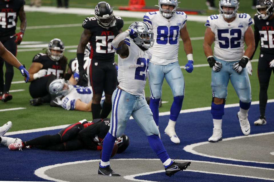 Dallas Cowboys running back Ezekiel Elliott (21) celebrates running the ball for a touchdown as Atlanta Falcons' Keanu Neal (22) checks on injured teammate Damontae Kazee, bottom, in the first half of an NFL football game in Arlington, Texas, Sunday, Sept. 20, 2020. (AP Photo/Ron Jenkins)