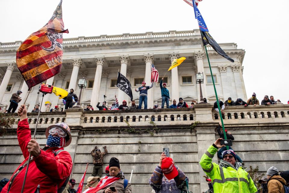 FILE -- Members of a mob incited by President Donald Trump climb the walls of the Capitol in Washington, Jan. 6, 2021. From congressional offices to community meeting rooms, threats of violence are becoming commonplace among a significant segment of the Republican Party, less than a year after rioters attacked the United States Capitol on Jan. 6. (Jason Andrew/The New York Times)