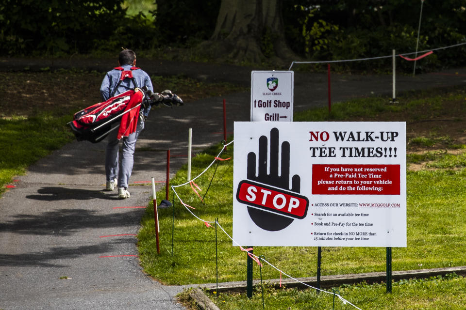 A golfers walk at the Sligo Creek Golf Course in Silver Spring, Md., Monday, May 11, 2020, as Maryland Gov. Larry Hogan opened golf courses in the initial stage in easing coronavirus shutdown. As states push for some return to normal business operations, elected officials in the Virginia and Maryland suburbs surrounding Washington, D.C., are unwilling to quickly reopen, as they confront COVID-19 infection and fatality numbers that are the highest in their states. (AP Photo/Manuel Balce Ceneta)