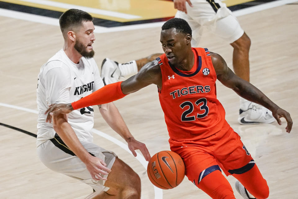Central Florida forward Sean Mobley, left, loses control of the ball as he tries to get around Auburn forward Jaylin Williams (23) during the second half of an NCAA college basketball game, Monday, Nov. 30, 2020, in Orlando, Fla. (AP Photo/John Raoux)