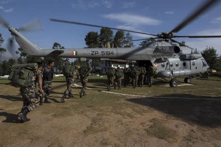 Nepal military personnel board an Indian Helicopter as they take part in earthquake relief operations after Tuesday's earthquake at Charikot Village, in Dolakha, Nepal, May 14, 2015. REUTERS/Athit Perawongmetha