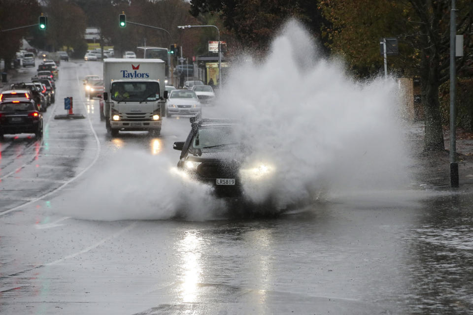 Cars plough through water in the flooded streets of central Auckland, New Zealand, Tuesday, May 9, 2023. Authorities in Auckland have declared a state of emergency as flooding again hits New Zealand's largest city.(Jason Oxenham/New Zealand Herald via AP)
