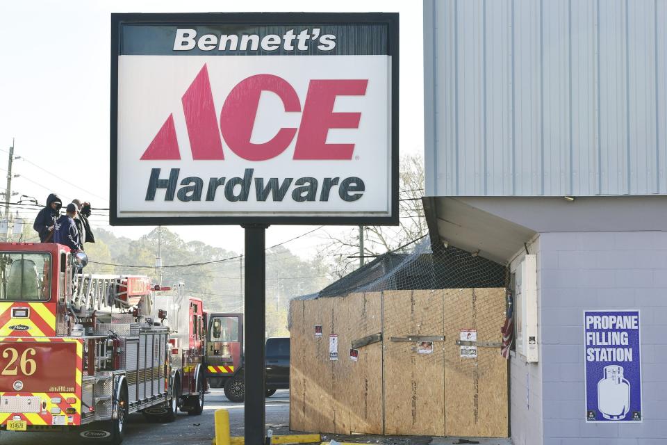 Jacksonville firefighters stand on Ladder 26 to view damage caused at Bennett's Ace Hardware in Marietta on Wednesday following the late Friday crash of a  semi, still sticking out of the boarded business Wednesday.