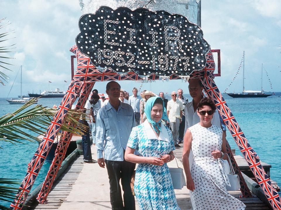 Queen Elizabeth II arrives in Mustique and is welcomed by Princess Margaret in 1977.