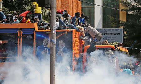 Supporters of the opposition National Super Alliance (NASA) coalition attempt to jump from their campaign truck after riot policemen fired teargas to disperse them during a demonstration calling for the removal of Independent Electoral and Boundaries Commission (IEBC) officials in Nairobi, Kenya September 26, 2017. REUTERS/Thomas Mukoya