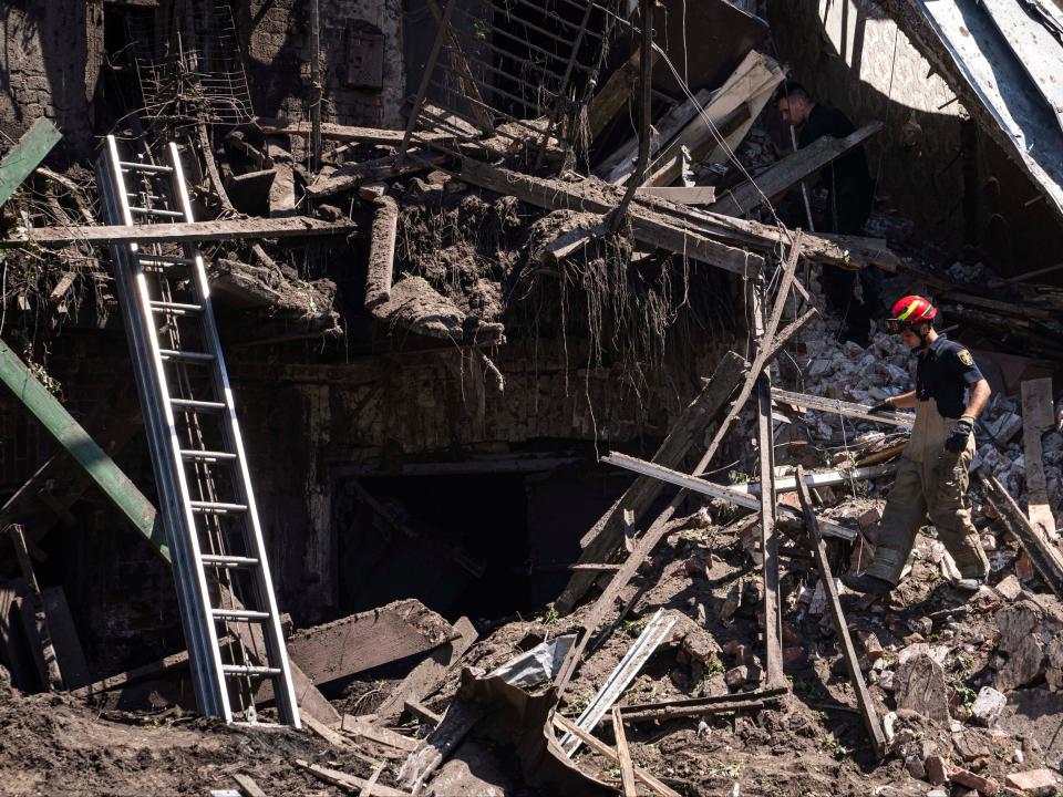 Rescue workers and police get to work on the site of a destroyed house in Kharkiv (AP)