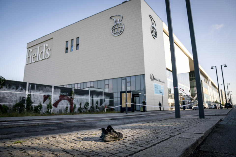 A shoe was abandoned in front of the shopping centre Fields, closed for at least a week after Sunday shooting, as police is investigating the crime scene the day after, in Copenhagen, Denmark, Monday, July 4, 2022. Danish police believe a shopping mall shooting that left three people dead and four others seriously wounded was not terror-related. They said Monday that the gunman acted alone and appears to have selected his victims at random. (Mads Claus Rasmussen/Ritzau Scanpix via AP)