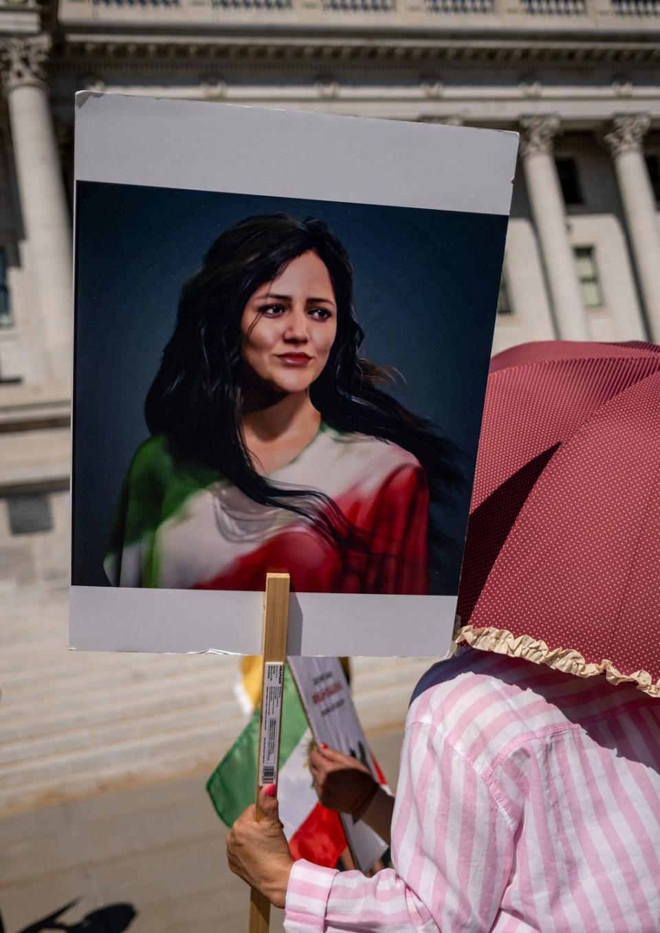 A woman holds a portrait of Mahsa Amini at a protest against the Iranian regime at the Capitol in Salt Lake City on Saturday. Amini died a year ago in the custody of Iran’s morality police after being arrested for allegedly violating the country’s strict dress code for women, sparking widespread protests.