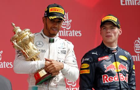 Britain Formula One - F1 - British Grand Prix 2016 - Silverstone, England - 10/7/16 Mercedes' Lewis Hamilton celebrates on the podium with the trophy after winning the race with third placed Max Verstappen of Red Bull REUTERS/Andrew Boyers Livepic EDITORIAL USE ONLY.