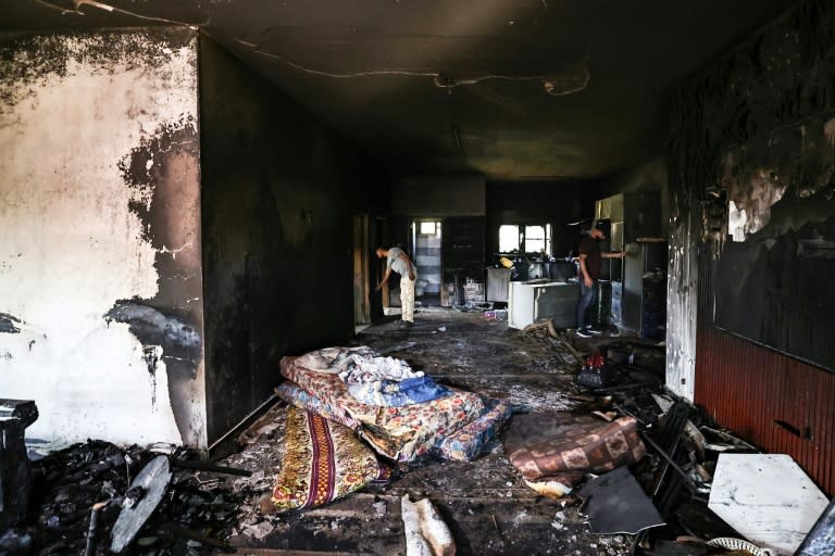 Habitantes de Duma, en Cisjordania ocupada, comprueban los daños causados por el fuego en una casa tras un ataque de colonos israelíes, el 17 de abril de 2024 (Zain JAAFAR)