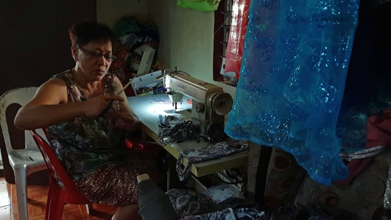 A seamstress sews protective masks to be donated to residents affected by the erupting Taal Volcano