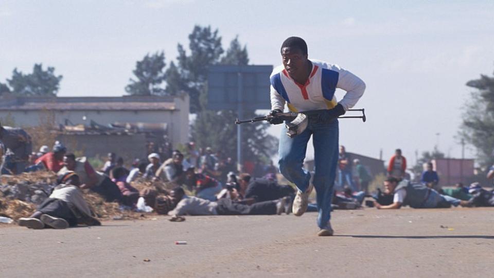 Ein bewaffneter Mann während der Gewalt in Thokaza zwischen Anhängern der Inkatha Freedom Party und dem African National Congress (ANC) in Südafrika – 1994
