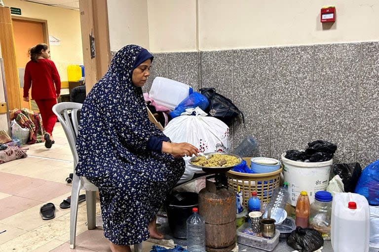 Una desplazada interna cocina mientras acampa en el hospital Al-Shifa de la ciudad de Gaza el 10 de noviembre de 2023, en medio de los combates en curso entre Israel y el movimiento palestino Hamas.