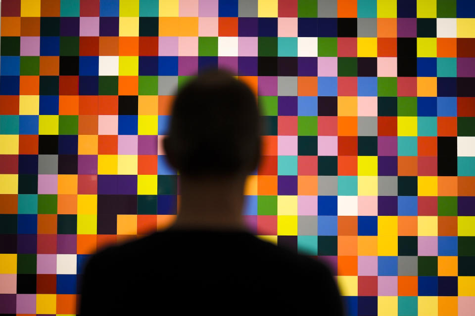 A man looks to a painting '4900 Colours (excerpt)' in a new exhibition with art works of German artist Gerhard Richter at the New National Gallery in Berlin, Germany, Friday, March 31, 2023. Richter's foundation gave on permanent loan 100 works of the artist to the New National Gallery where they will be shown in the permanent exhibition. (AP Photo/Markus Schreiber)