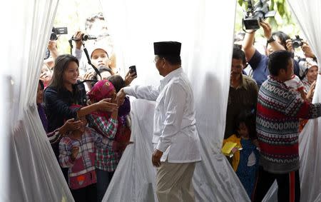 Villagers greet Indonesian presidential candidate Prabowo Subianto (C) after he voted during the presidential election, at Bojong Koneng polling station in Bogor July 9, 2014. . REUTERS/Beawiharta