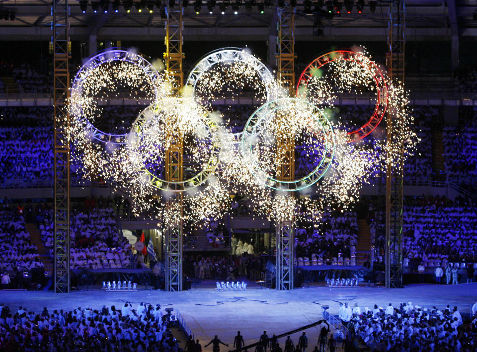 FILE - The Olympic Rings light up the stadium during opening ceremonies for the Turin 2006 Winter Olympic Games in Turin, Italy, Friday, Feb. 10, 2006. Creative director Marco Balich, reveals to The Associated Press that he has been working for a year on a 30-minute show that will run ahead of the Soccer World Cup 2022 opening game between Qatar and Ecuador. He says local organizers "wanted to create a real show, which FIFA is not accustomed to.”(AP Photo/Kevork Djansezian, Pool, File)