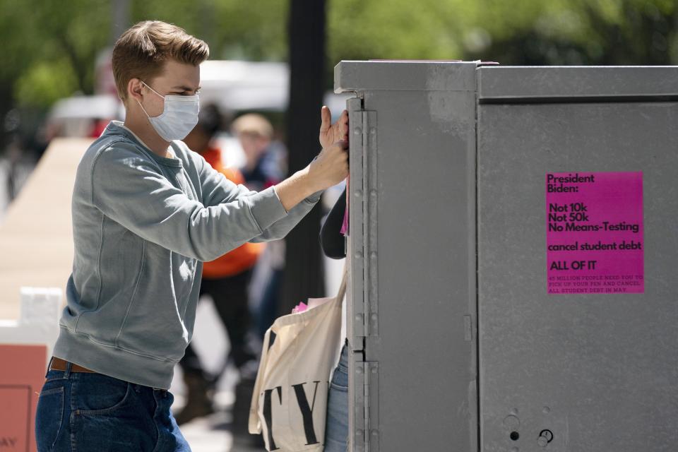 George Washington University student Kai Nilsen puts up posters near the White House promoting student loan debt forgiveness, April 29 in Washington.