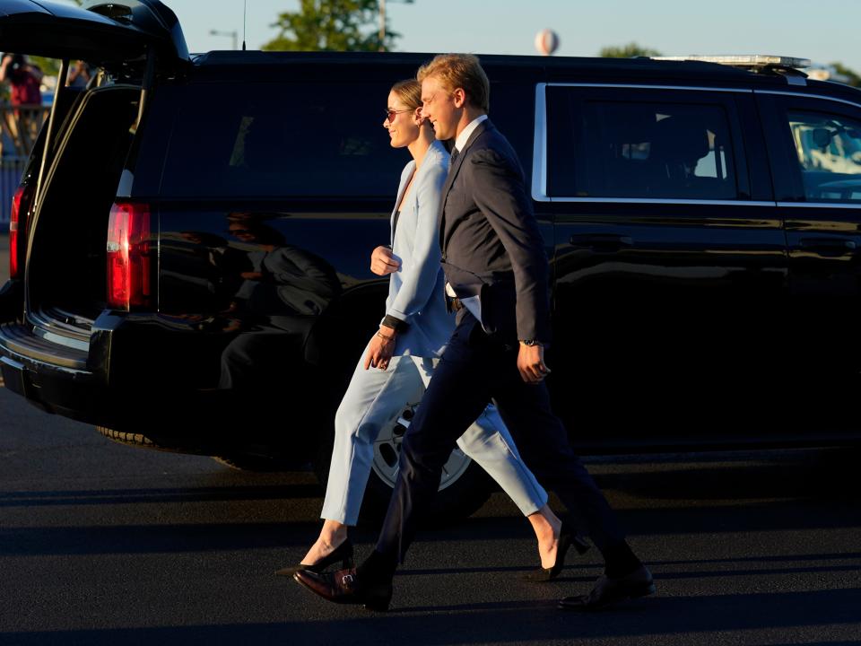 Naomi Biden and her fiancé Peter Neal walk in front of a black presidential car