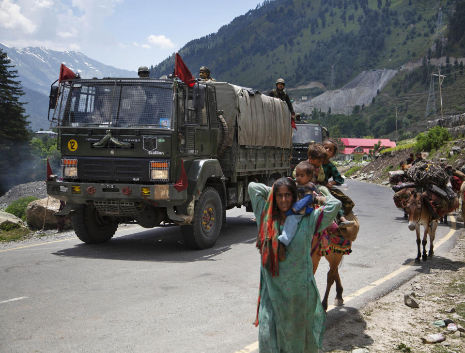 Kashmiri Bakarwal nomads walk as an Indian army convoy moves on the Srinagar- Ladakh highway at Gagangeer, north-east of Srinagar, India, Wednesday, June 17, 2020. Indian security forces said neither side fired any shots in the clash in the Ladakh region late Monday that was the first deadly confrontation on the disputed border between India and China since 1975. China said Wednesday that it is seeking a peaceful resolution to its Himalayan border dispute with India following the death of 20 Indian soldiers in the most violent confrontation in decades. (AP Photo/Mukhtar Khan)