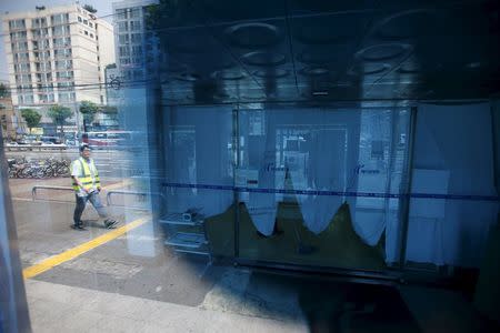 Curtains are drawn at an entrance as a worker walks past a hospital which is sealed off temporarily, in Seoul, South Korea, June 16, 2015. REUTERS/Kim Hong-Ji