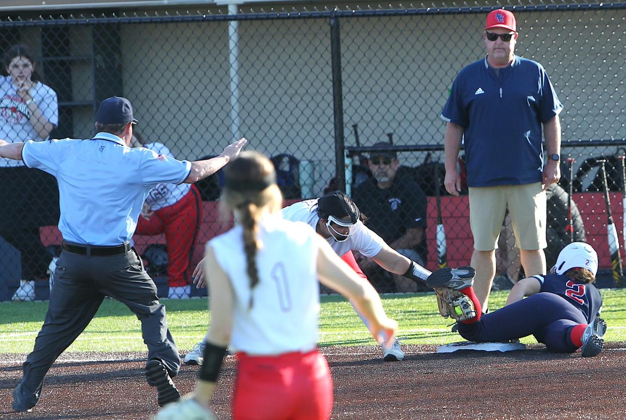 Bedford North Lawrence's Macee Nicholson slides safely into third. BNL Coach Brad Gilbert is standing near third base on Monday, April 29, 2024.