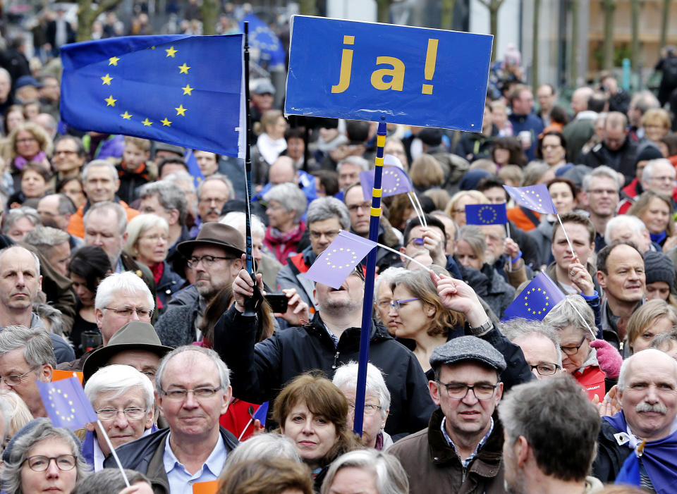 Supporters wave a European flags and hold a poster reading 'yes' as they attend a rally of the Pulse of Europe movement in Frankfurt, Germany, Sunday, March 19, 2017. Pulse of Europe goes to the streets equipped with the symbols of Europe, flags and Ode to Joy. The protesters take a stand for Europe in public for everyone to see. (AP Photo/Michael Probst)