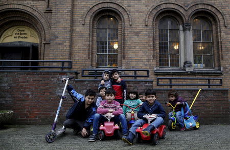 Migrant children from Syria pose in front of a Protestant church in Oberhausen, Germany, November 19, 2015. REUTERS/Ina Fassbender