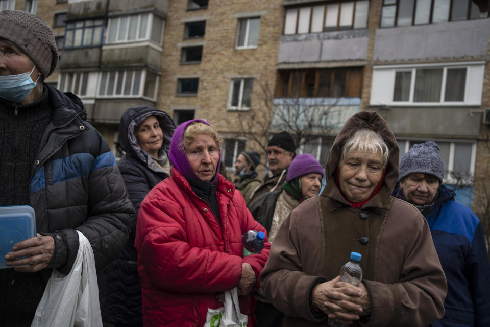 A group of women wait to receive free food from a soup kitchen in Bucha, in the outskirts of Kyiv, Ukraine, Saturday, April 9, 2022. (AP Photo/Rodrigo Abd)