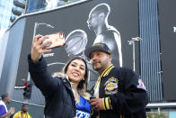 Alyssa Quevedo and her husband Emmanuel take a selfie in front of a mural of Kobe Bryant near the Staples Center before a public memorial for former Los Angeles Lakers star Kobe Bryant and his daughter, Gianna, in Los Angeles, Monday, Feb. 24, 2020. (AP Photo/Ringo H.W. Chiu)