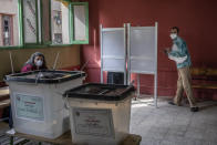 A man prepares to cast ballot on the first day of the parliamentary election inside a polling station in Giza, Egypt, Saturday, Oct. 24, 2020. Egyptians began voting Saturday in the first stage of a parliamentary election, a vote that is highly likely to produce a toothless House of Representatives packed with supporters of President Abdel-Fattah el-Sissi. (AP Photo/Nariman El-Mofty)